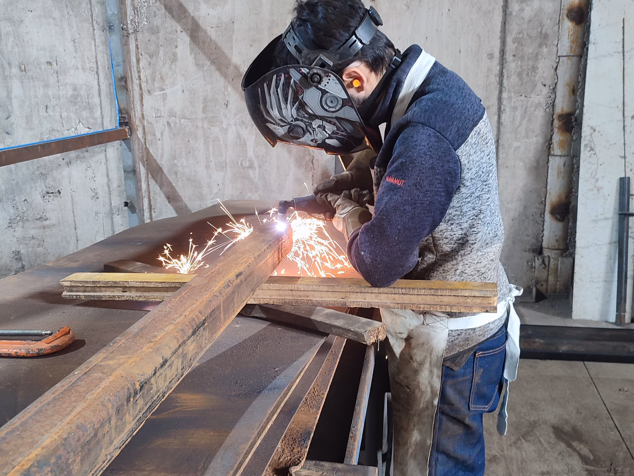 Soldador trabajando el acero en el taller de Mech Industries